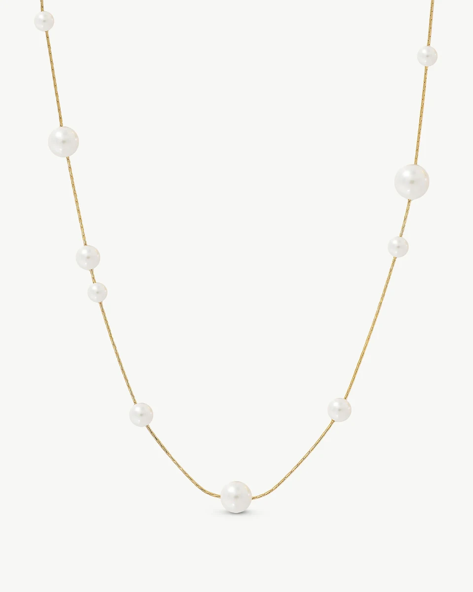 Collar de perlas blancas sobre fondo blanco, vista frontal con caída en forma de U.