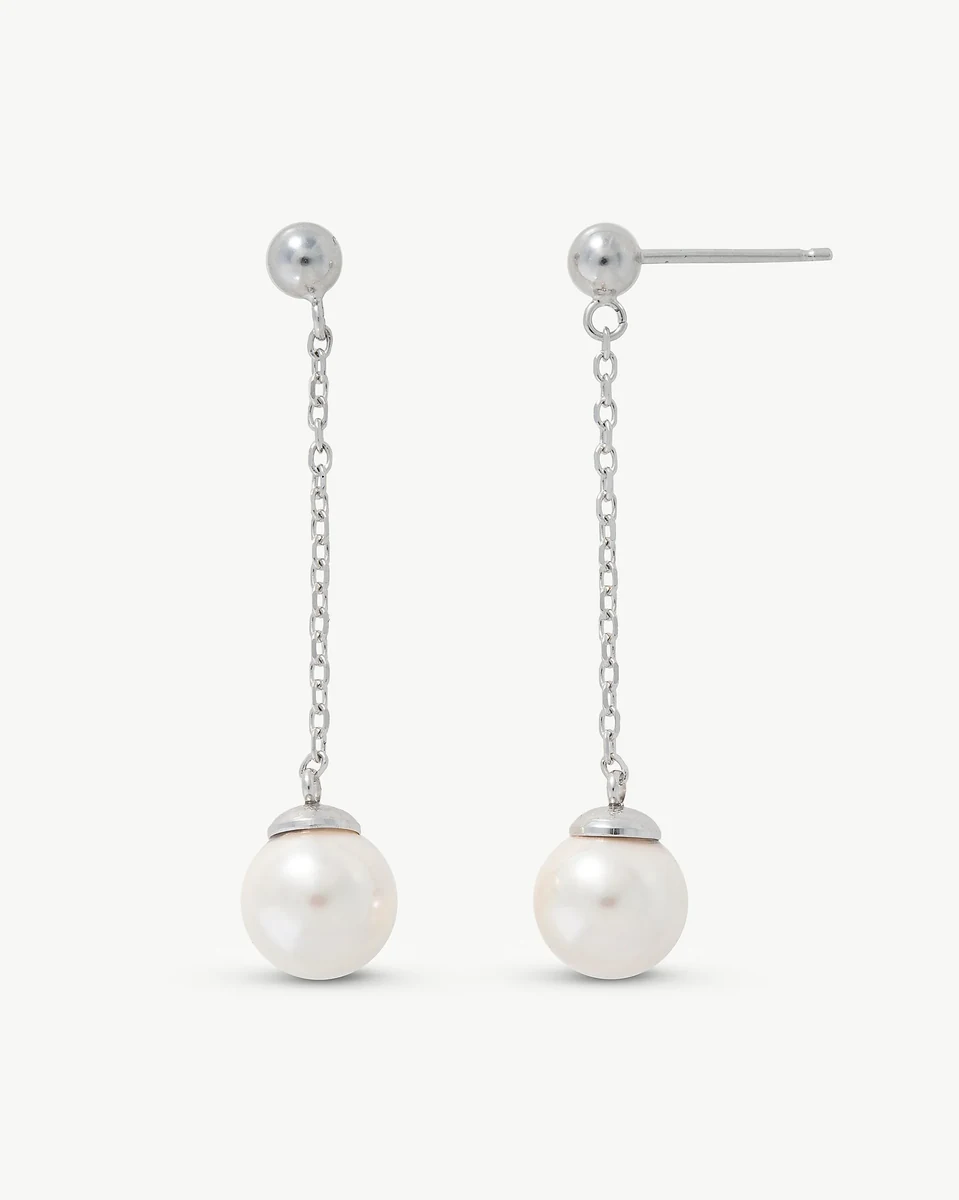 Front view of long pearl drop earrings on a white background, showing the chain and stud detail.