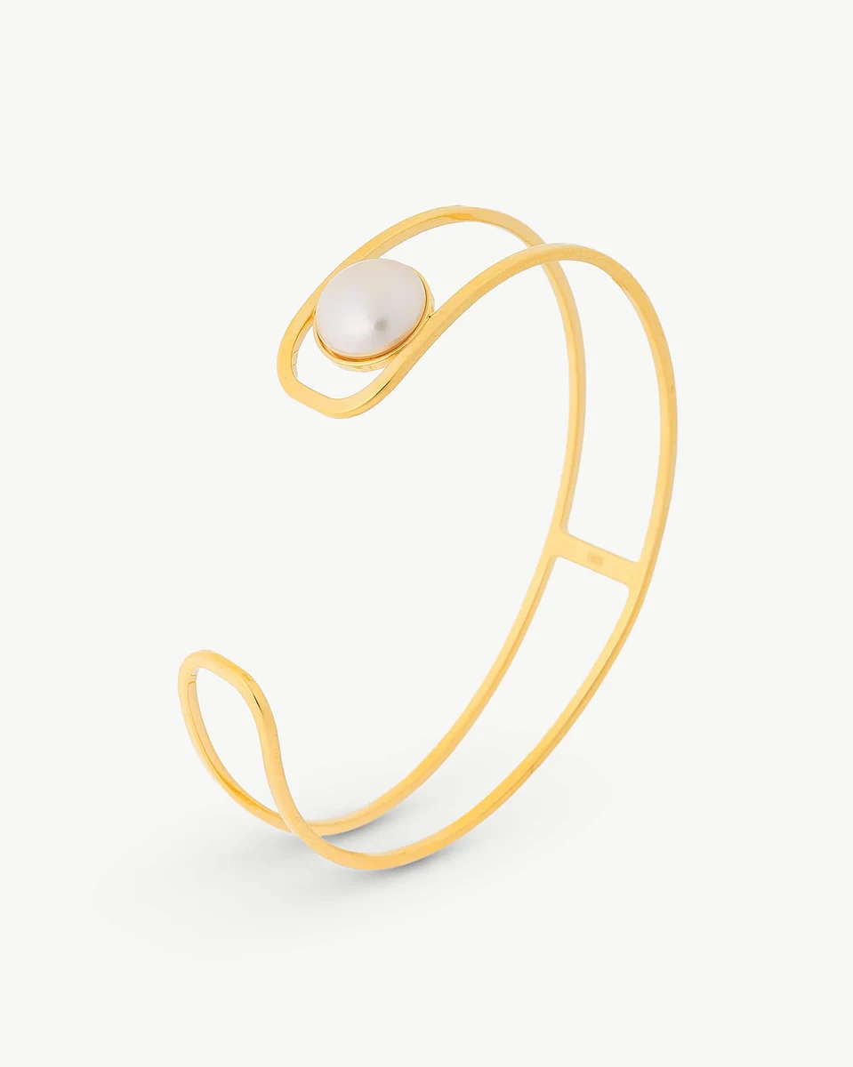 Bracelet doré avec perle blanche vu de profil sur fond blanc.