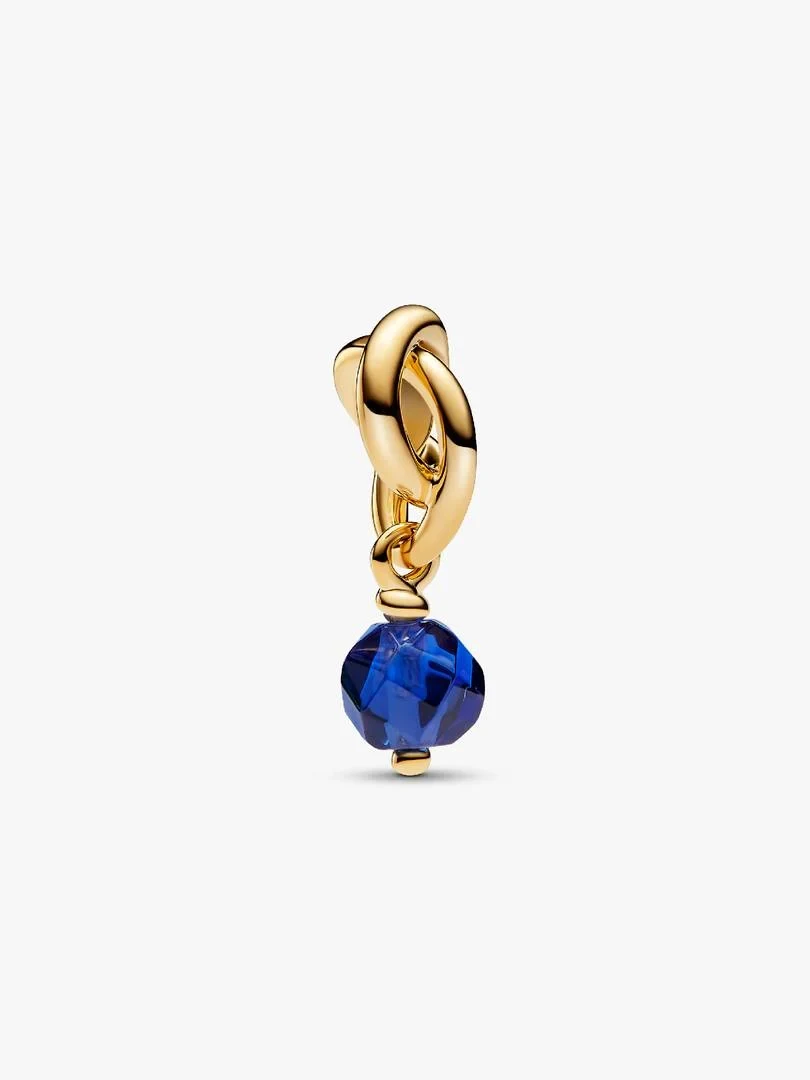 Gold charm pendant with faceted blue crystal, front view on a white background.