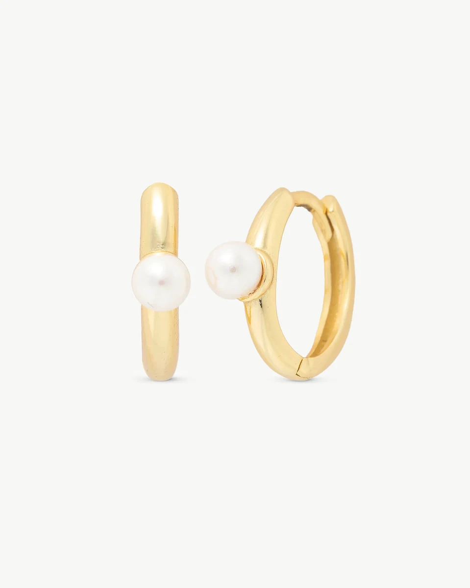Vista frontal de los pendientes de aro con perla, ángulo ligeramente lateral sobre fondo blanco.