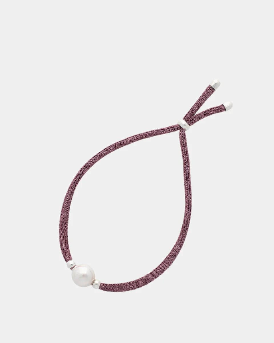 Magenta bracelet with white pearl, front view on white background, detail of the adjustable closure.