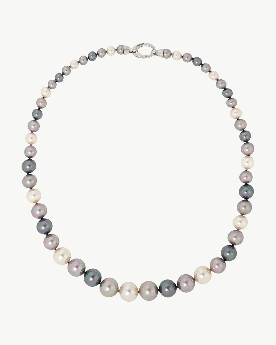 Collar de perlas multicolor dispuesto en círculo sobre fondo blanco, vista cenital con cierre de plata visible.