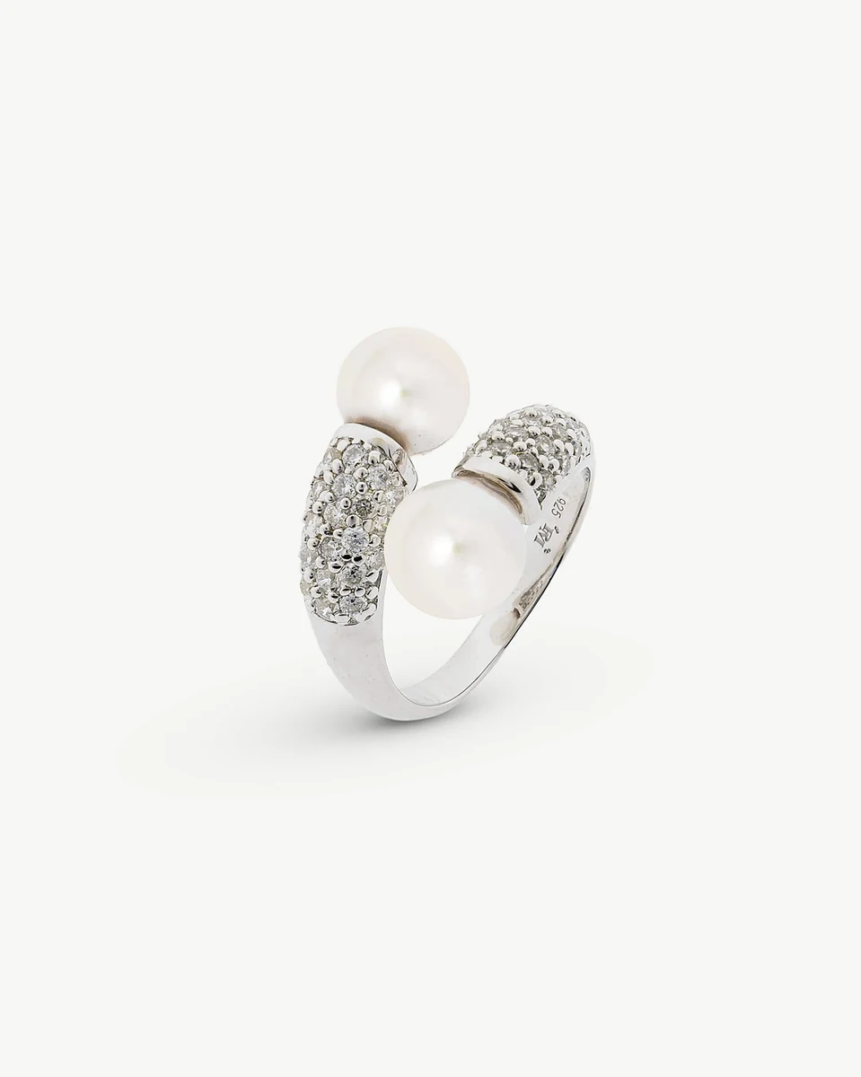 Bague ouverte en argent avec deux perles blanches, vue de trois quarts sur fond blanc.