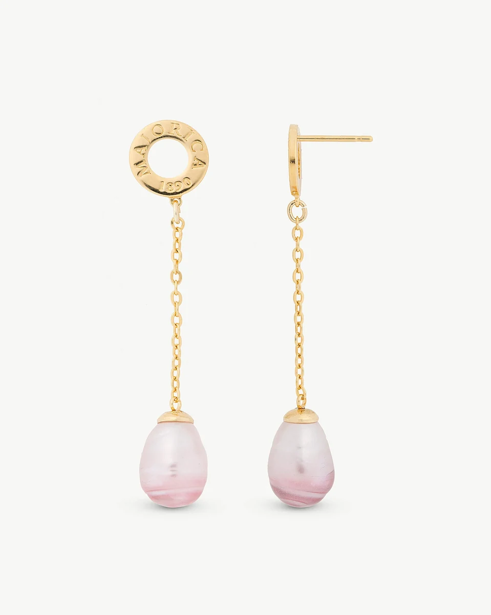 Vista frontal de los pendientes largos con perlas barrocas rosadas y cadena dorada sobre fondo blanco.