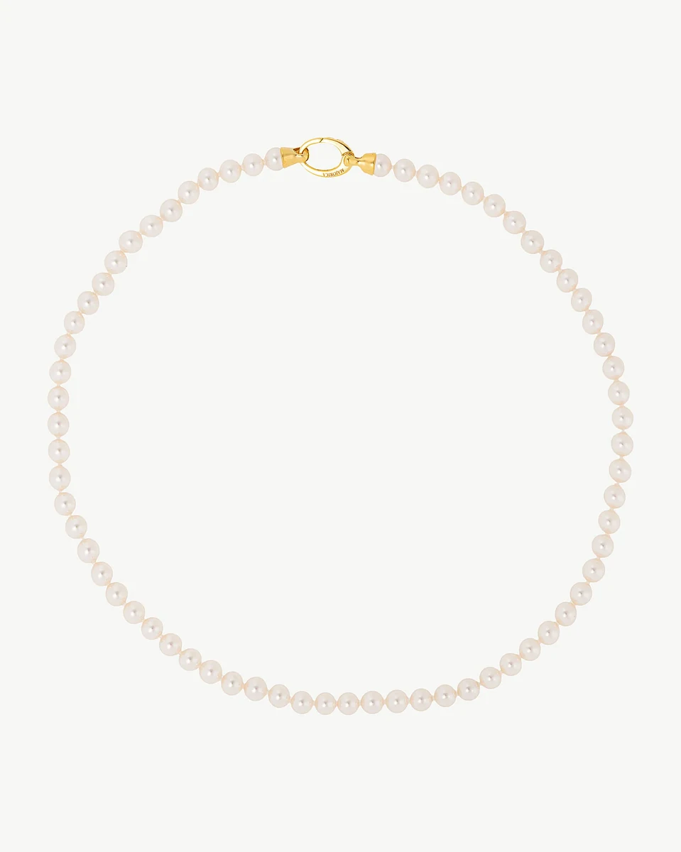 Pearl necklace arranged in a circle on a white background, front view with gold clasp visible.