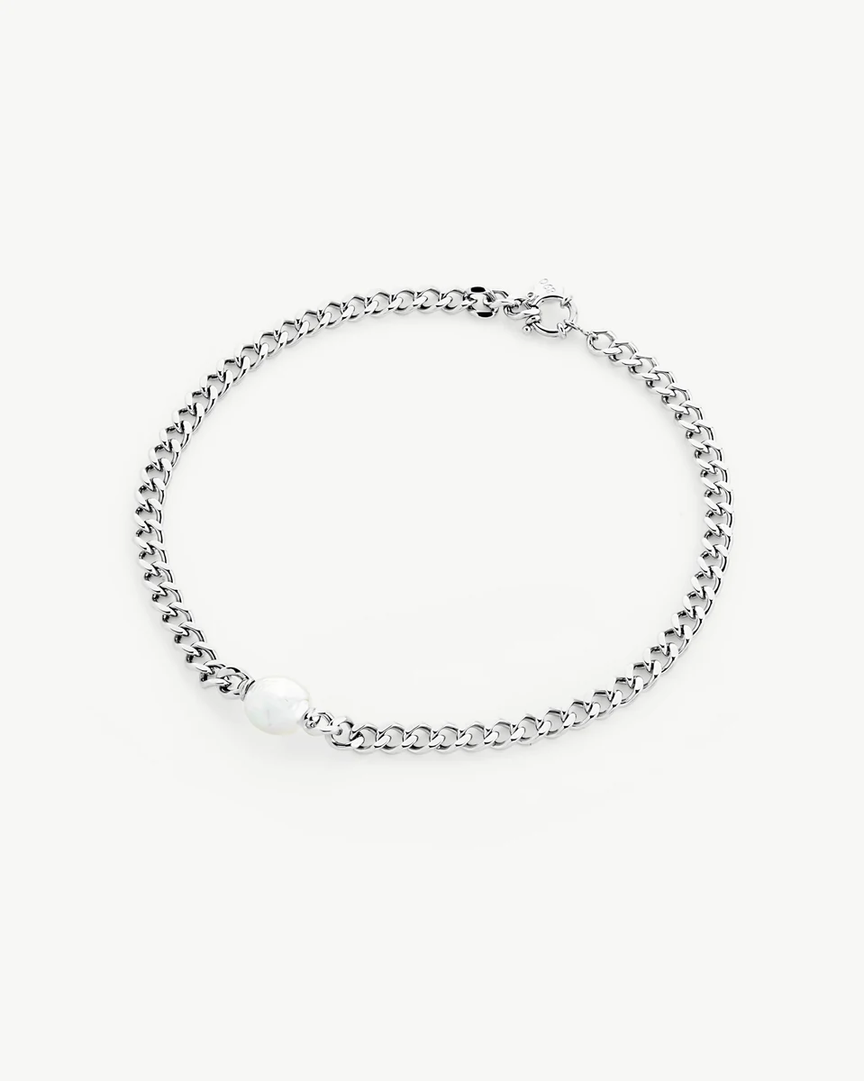 Halskette kreisförmig auf weißem Hintergrund angeordnet, mit der ovalen Perle unten.