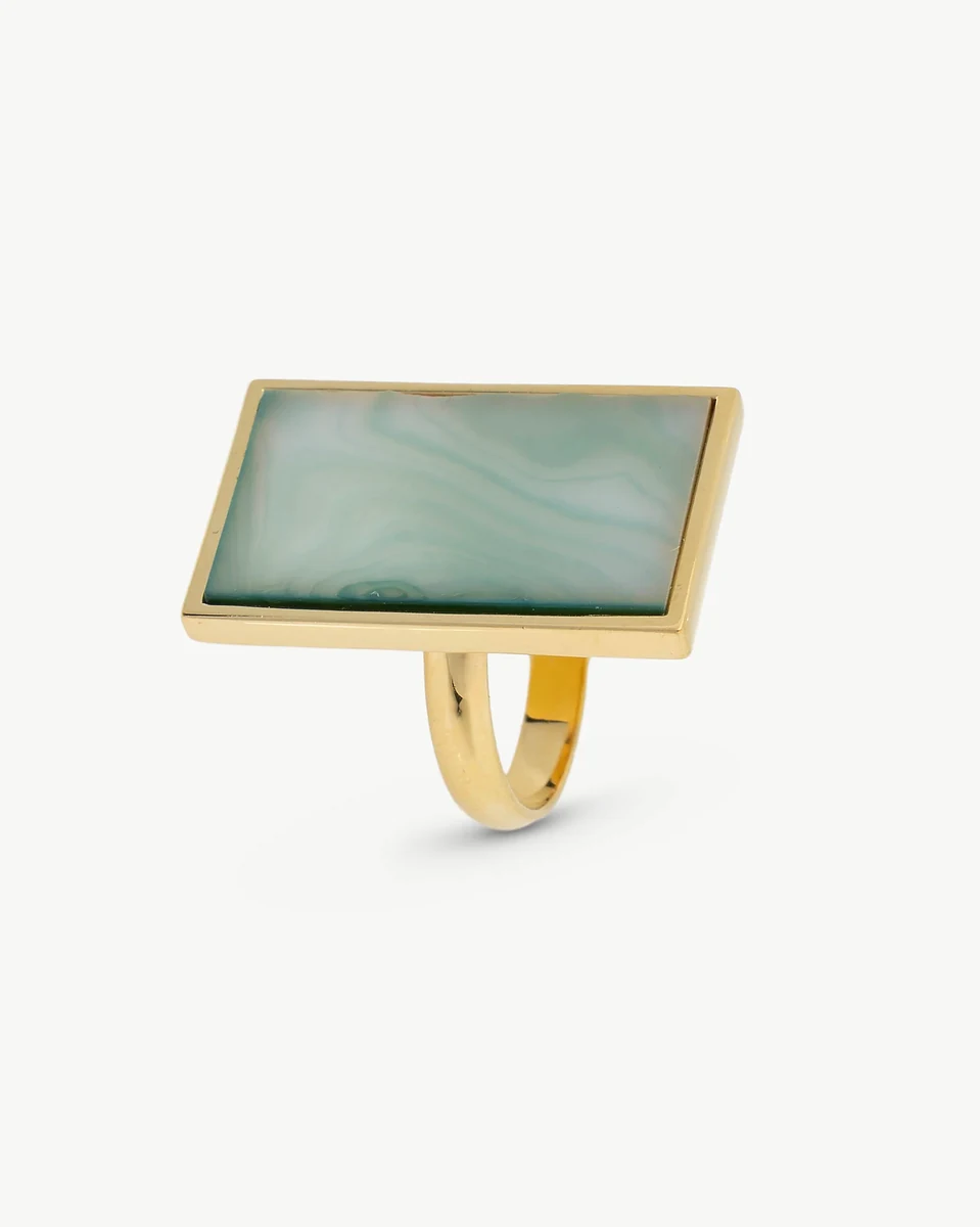 Anillo con pastilla rectangular de nácar verde, vista lateral en ángulo, sobre fondo blanco.