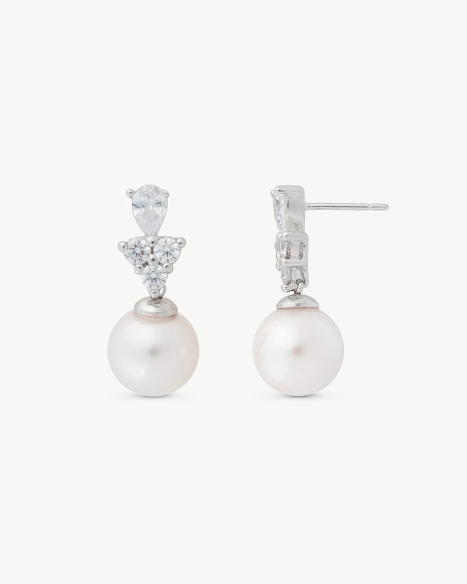 Front and side view of the earrings, white background, detail of zircon settings and pearl.