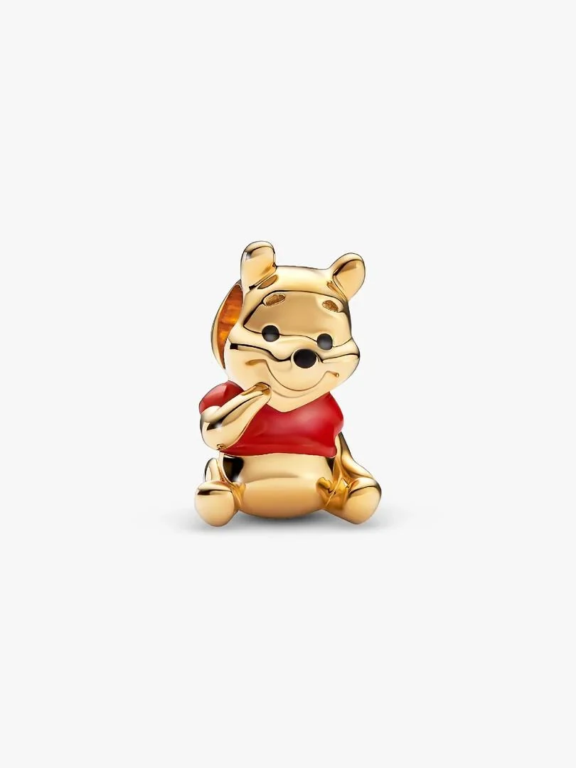 Charm de Winnie the Pooh sentado con camiseta roja, vista frontal en ángulo, fondo blanco.