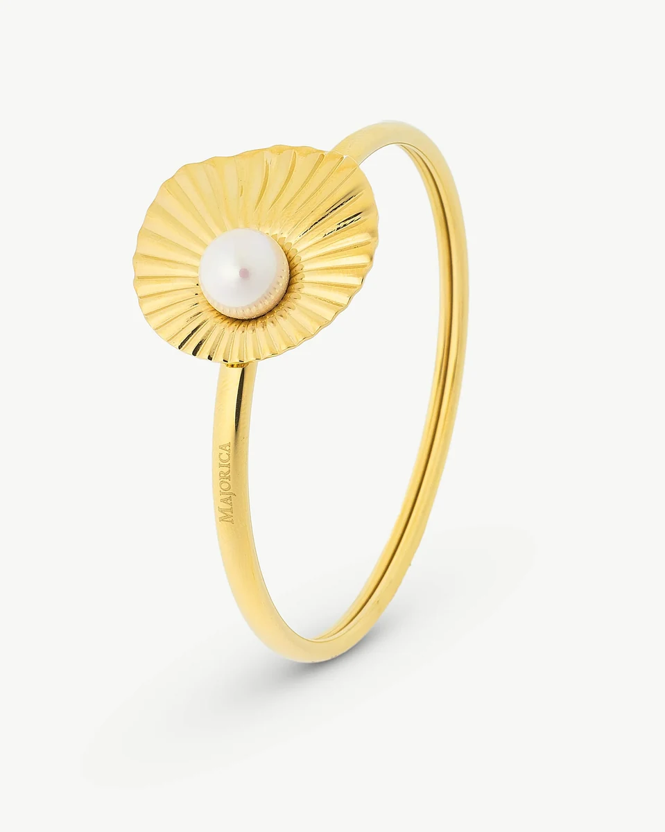 Bracelet jonc doré avec perle centrale motif soleil, vue de profil sur fond blanc.