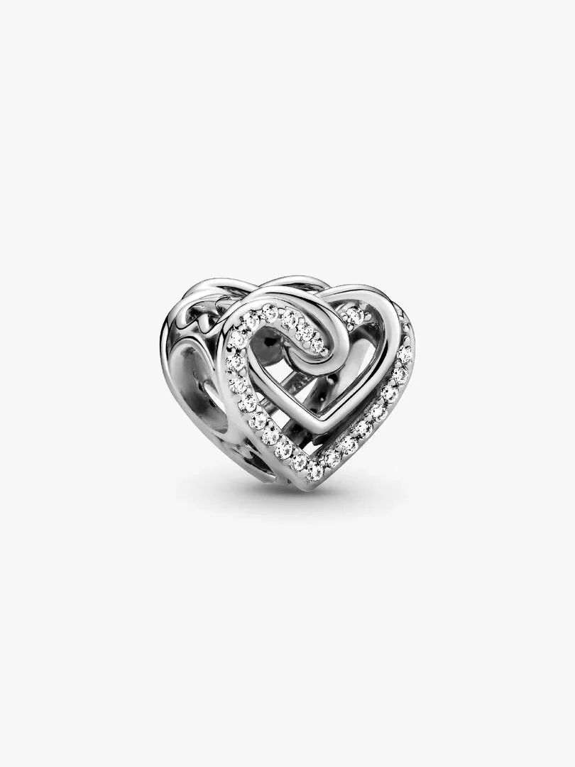 Interlocking heart charm in silver with cubic zirconia, angled side view on a white background.