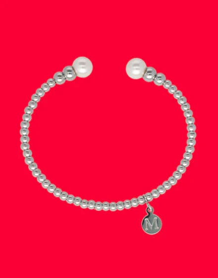 Bracelet semi-rigide avec perles blanches et billes d'acier sur fond rouge vif, vue de face.