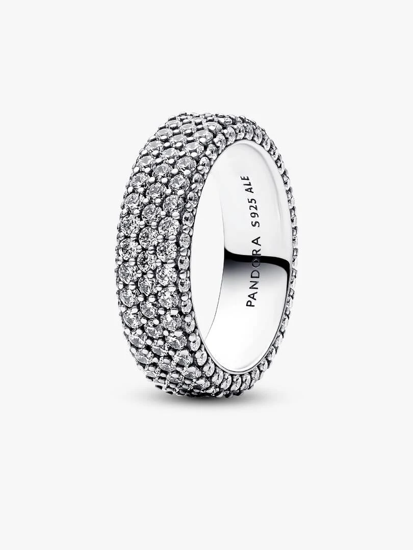 Anillo de tres filas de pavé visto desde un ángulo lateral, fondo blanco, detalle del grabado interno.