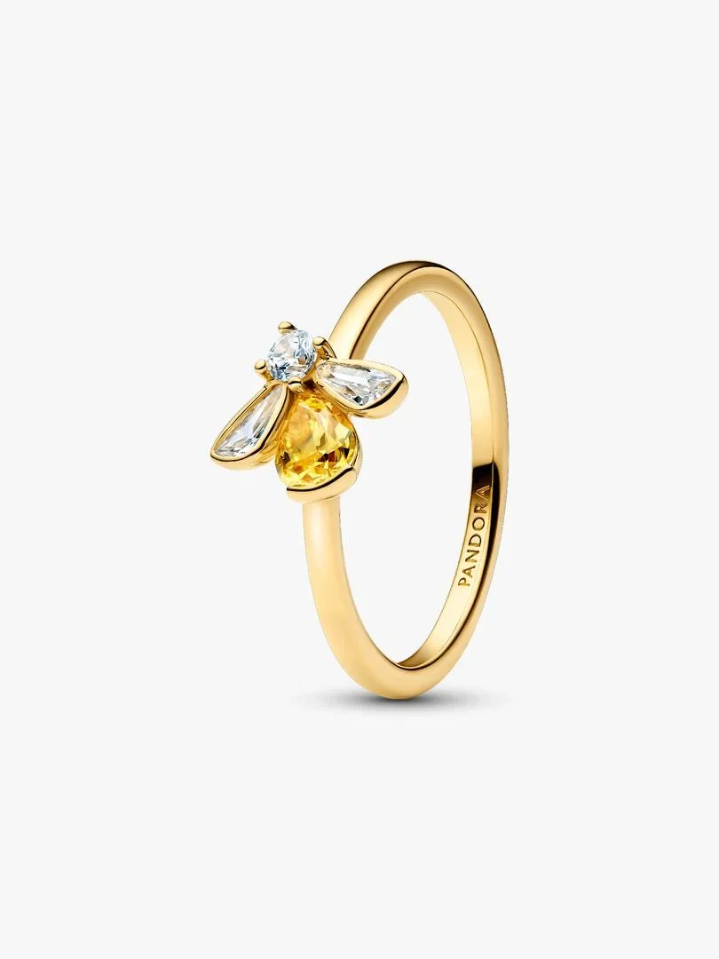 Bague abeille au corps jaune et ailes transparentes, vue de profil sur fond blanc.