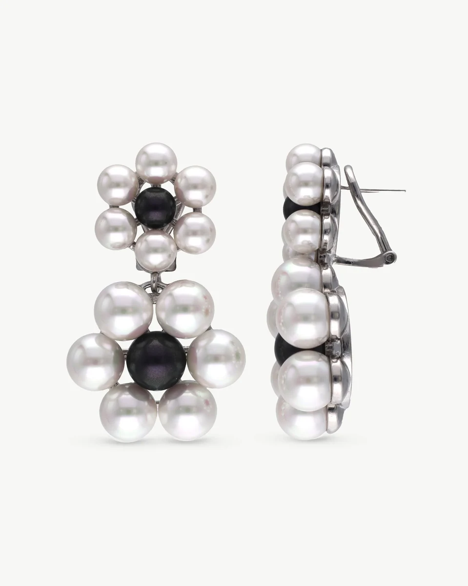 Front and side view of white and black pearl flower earrings on a white background.