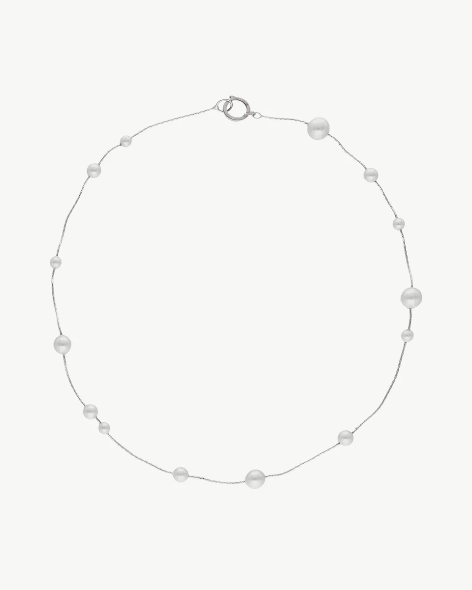 Collar de perlas blancas sobre fondo blanco, vista frontal completa con cierre de mosquetón visible.