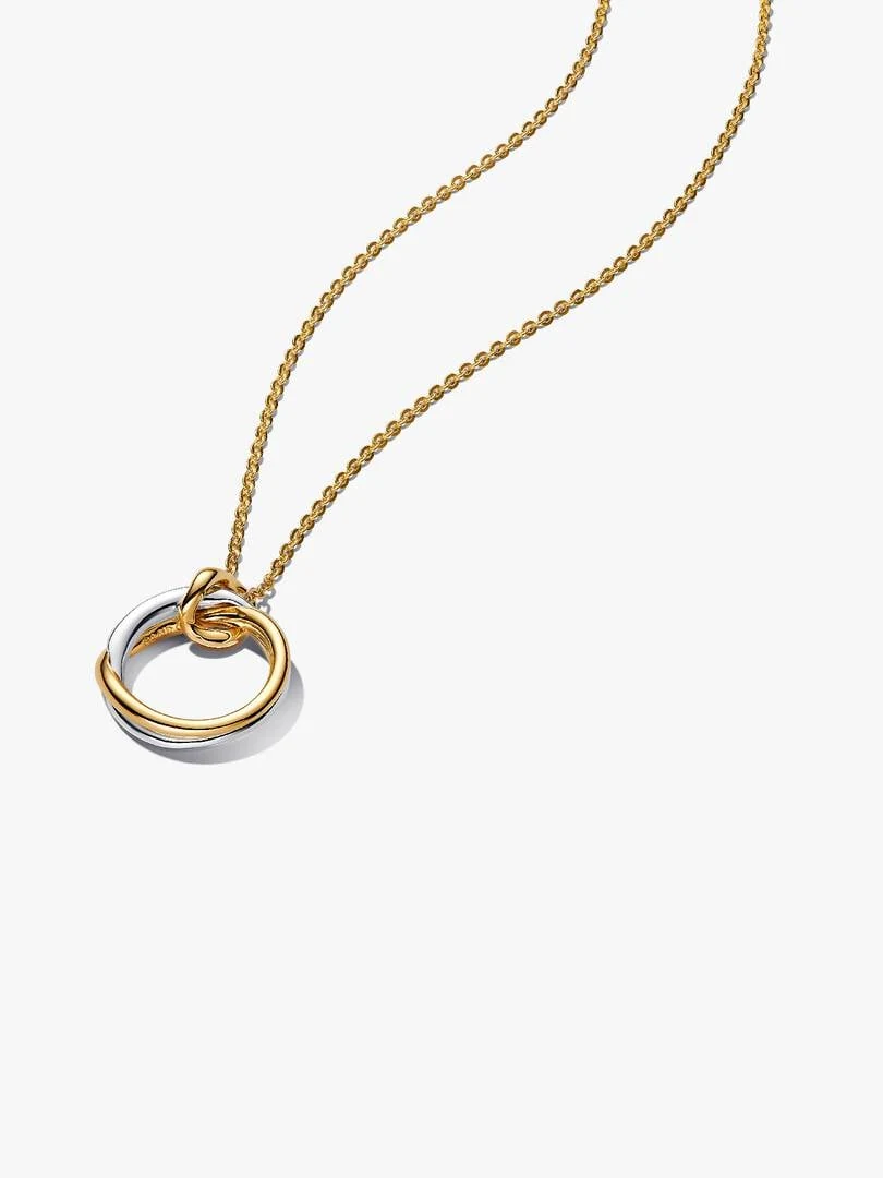 Collar con colgante orgánico en dos tonos sobre fondo blanco, toma frontal con ángulo ligeramente inclinado.