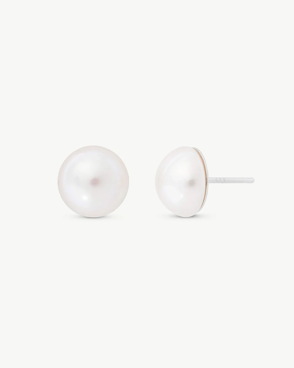 Paire de boucles d'oreilles demi-perle blanche sur fond blanc, vue de face avec une boucle de profil.