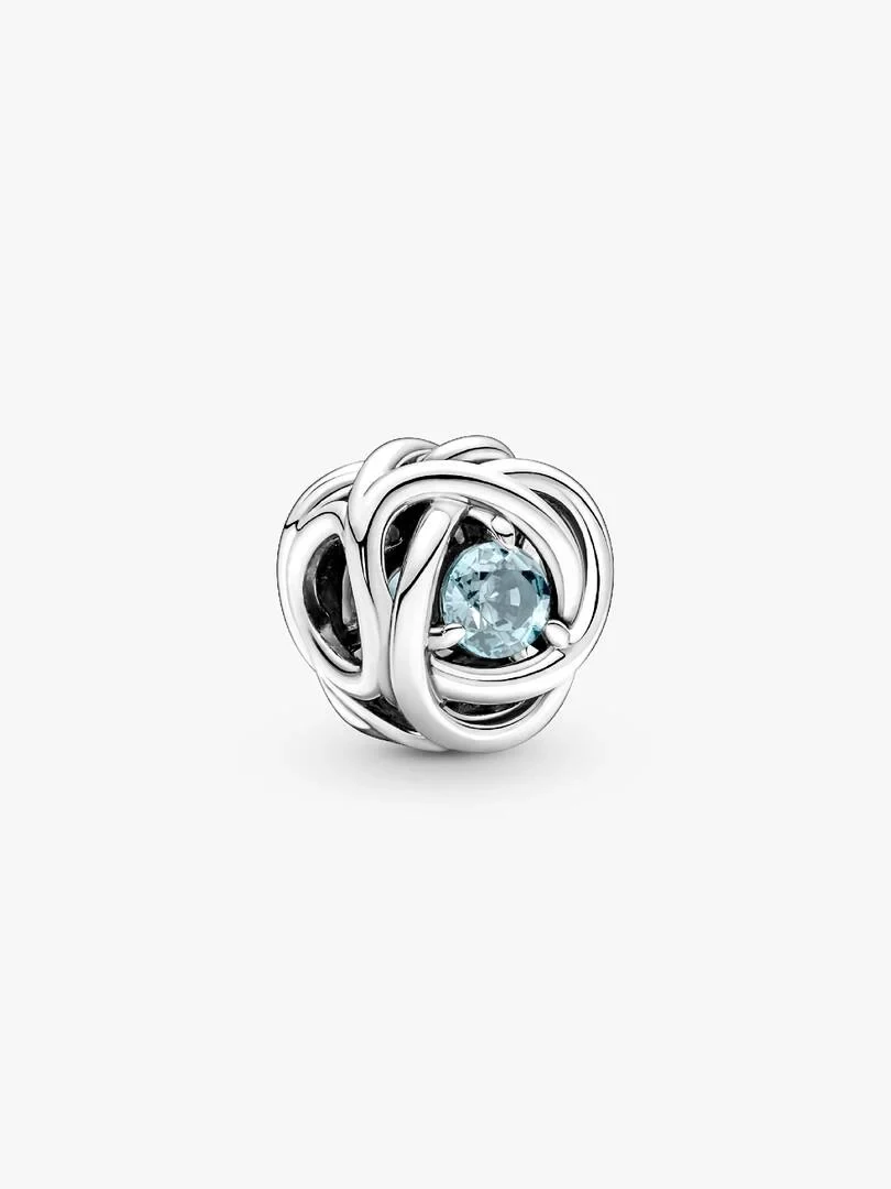 Charm en argent au design tressé et cristal bleu central, vue de face sur fond blanc.