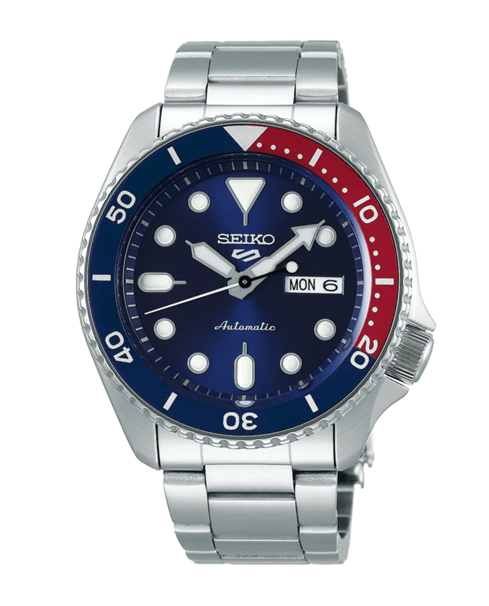 Vista frontal de reloj con bisel bicolor azul y rojo, esfera azul y brazalete de acero sobre fondo blanco.